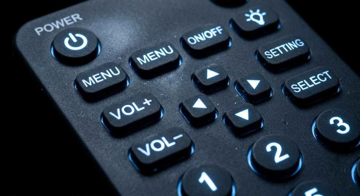 LED-backlit translucent silicone keypad with laser-etched characters lit in cool white on a dark gray matte surface